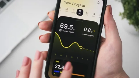 Woman adding her weight data and checking her weightloss progress. Tracking Stock Footage 234055779