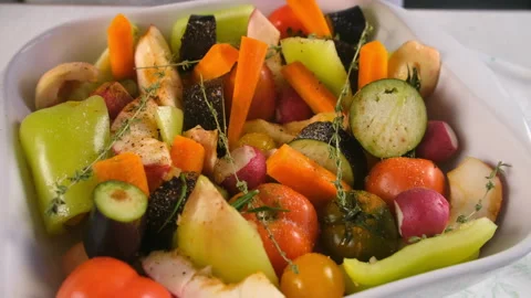 Woman adding herbs thyme, rosemary to fresh vegetables fruit on baking sheet. Stock Footage 312461296