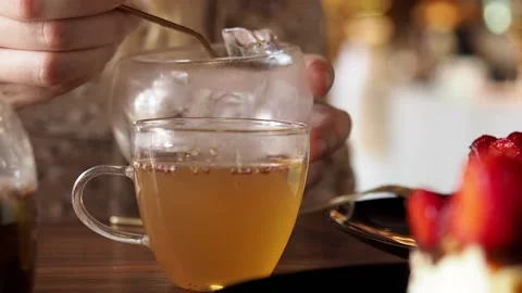 Woman adding ice cube to herbal tea  Stock Footage 200071437
