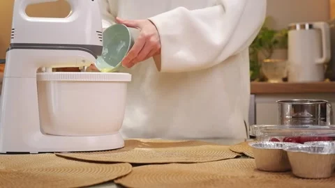 Woman adding ingredients for baking with a stand mixer Stock Footage 309864141