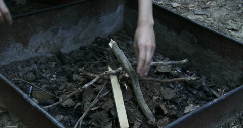 Woman adding kindling on fire pit Stock Footage 39298506