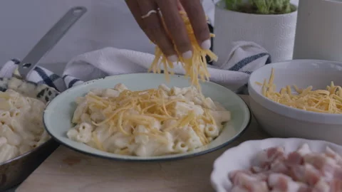 Woman adding mozzarella or cheddar cheese to pasta Stock Footage 255007936