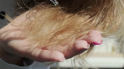 Woman adding oil to her split ends of hair. REpairing hair season of loss hair Stock Footage 170810330