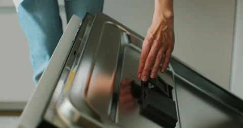 Woman adding rinse aid tablets detergent. Woman preparing to washing plates Stock Footage 196817591