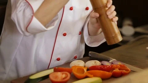 Woman adding salt to the vegetable salad, closeup Stock Footage 74716092