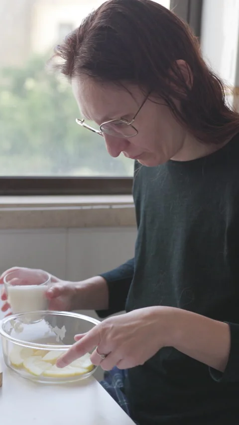 Woman adding sugar to sliced apples in glass bowl Stock Footage 326769996