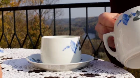 Woman Adding Sugar to Tea and Reading a Book on the Terrace in an Autumn Day Stock Footage 267482323