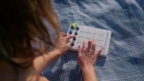 Woman Adjusting Knobs on Portable Midi Drum Pad Synthesizer Outdoors Stock-Footage 342771074