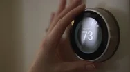 Woman Adjusting Smart Thermostat Gadget At Home Stock Footage