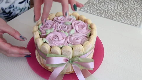 Woman adjusts cake elements. Cake with Savoiardi cookies and marshmallow rose Stock Footage 170642552