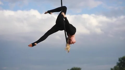 Woman aerialist performs acrobatic elements in hanging aerial hoop. 動画素材 137030491