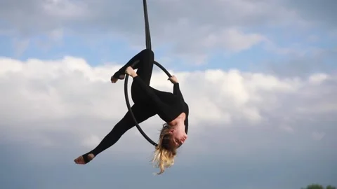 Woman aerialist performs acrobatic elements and spins in hanging aerial hoop. 動画素材 137030557