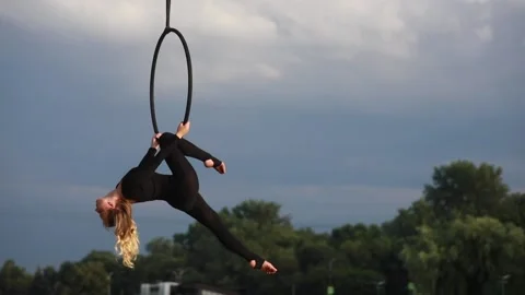 Woman aerialist performs acrobatic elements in hanging aerial hoop. 動画素材 137030602