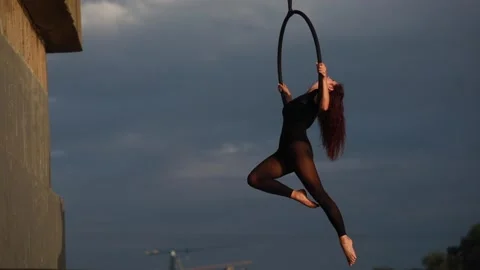 Woman aerialist performs acrobatic elements and spins in hanging aerial hoop. Stock Footage 137030905