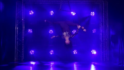 Woman aerialist performs acrobatic elements and spins in hanging aerial hoop Stock Footage 138857830