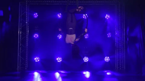 Woman aerialist performs acrobatic elements and spins in hanging aerial hoop Stock Footage 138864311