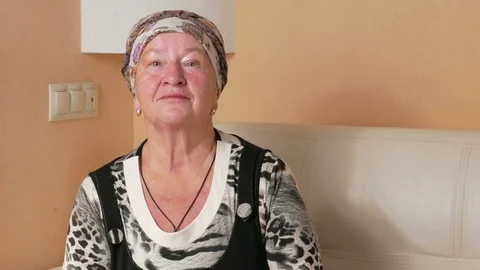 Woman aged seriously looking at the camera and looks around. Portrait of a Video stock 70131359