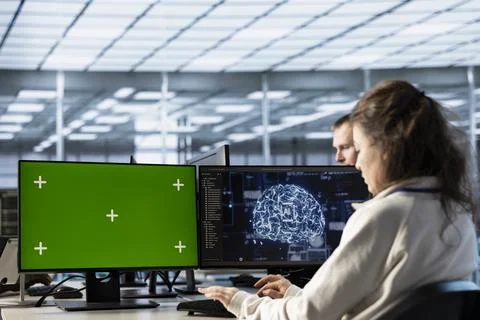 Woman in AI data center coding on green screen computers Stock Photos