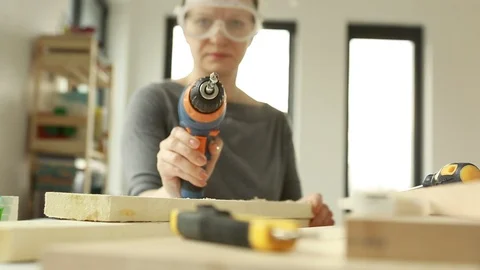 Woman aiming a drill at the camera. Drill in the hand of a young woman.   Stock Footage 106397207