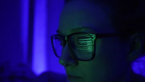 Woman analyst or programmer works at a computer in glasses close-up. The binary Stock Footage 235823141