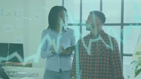 Woman analyst tapping tablet and reviewing data with peer while teal line graph Stock Footage 334702961