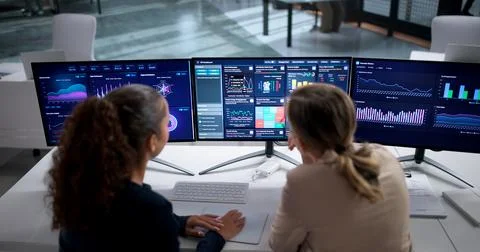 Woman Analyzing Business Data On Computer Screens In Corporate Office. Foto stock