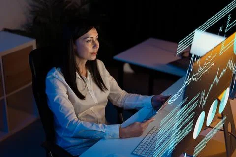 Woman Analyzing Data on Computer Screen in Modern Office Foto stock