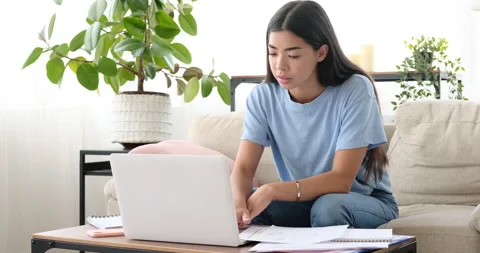 Woman analyzing document and using laptop at home Video stock 138324436