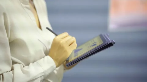 Woman analyzing financial data on a tablet with a stylus.  Vídeos de archivo 320536652