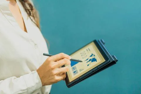 Woman analyzing financial data on a tablet with a stylus. Foto stock
