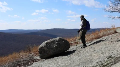 Woman and dog hiking reach the peak of the mountain slo motion Stock Footage