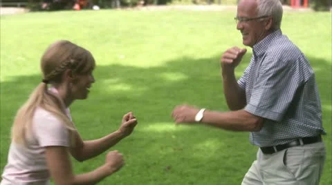 A woman and an elderly man pretending to fight Stock Footage