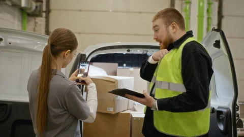 Woman and Man Checking Cargo in Delivery Van and Signing Paperwork Stock Footage 340289977