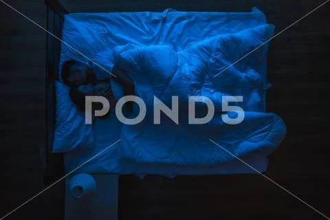The woman and man sleeping on the bed. Evening night time. View from above Stock Photos