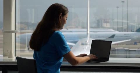 Woman answer email on laptop while waiting at airport Stock Footage 309442415