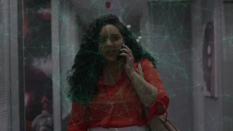 Woman answering work call while walking hall, green web overlay mapping data as Stock Footage 329812872