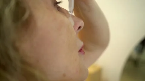 Woman applies second layer of multi-step skin care, gently distributing serum Stock Footage 301519522