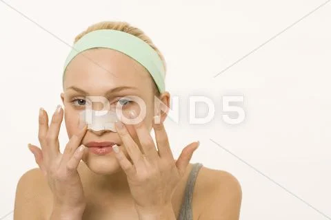 Woman applying adhesive plaster over nose, portrait Stock Photos