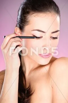 Woman applying cosmetic pencil Stock Photos