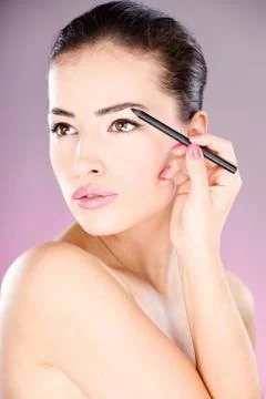 Woman applying cosmetic pencil Stock Photos