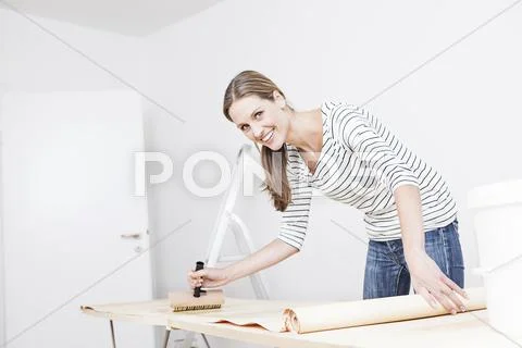 Woman applying glue on wallpaper Stock Photos