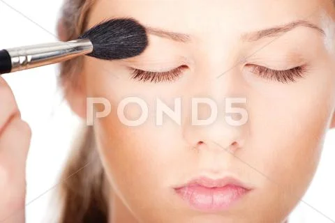 Woman applying make up with brush Stock Photos