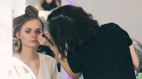 Woman applying make-up by make-up artist. Draws shadows Stock Footage 59602195