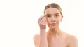 The woman applying makeup on her face on the white background 4k or 4k+ Resolution