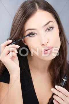 Woman applying mascara Stock Photos