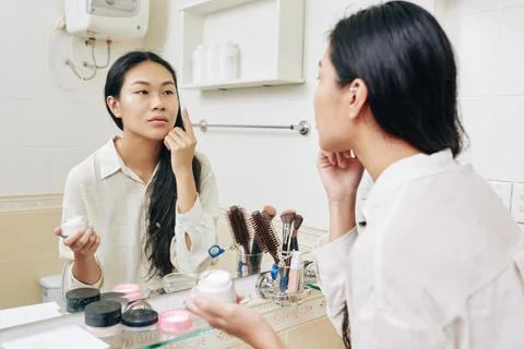 Woman applying moisturizer Stock Photos