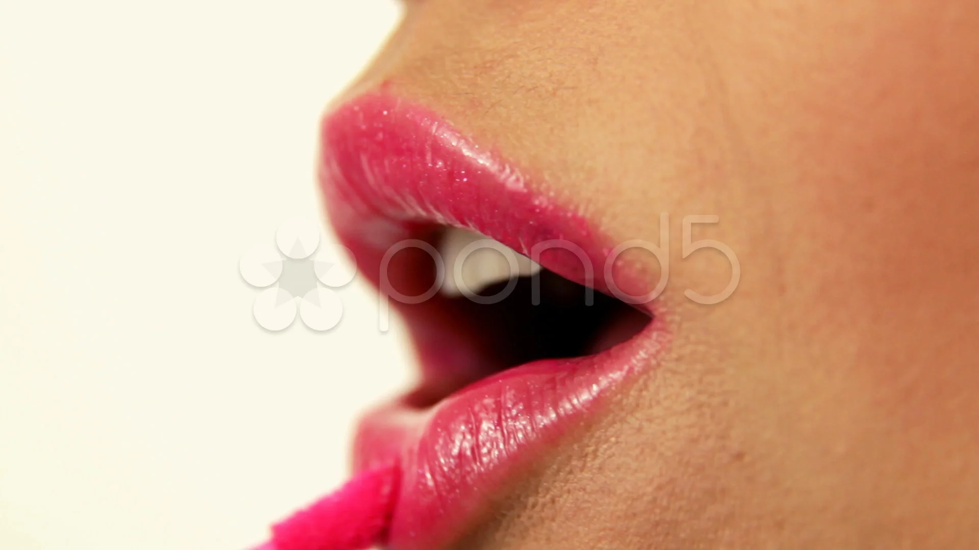 applying pink lipstick