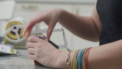 Woman applying shipping barcode labels with handheld label applicator to packets Stock Footage 263048050