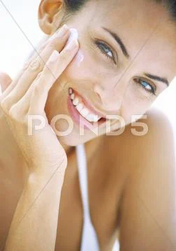 Woman Applying Sunscreen To Face, Close-Up