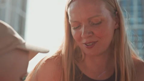 Woman applying sunscreen to face while interacting with child in bright sunlight Stock Footage 345969150
